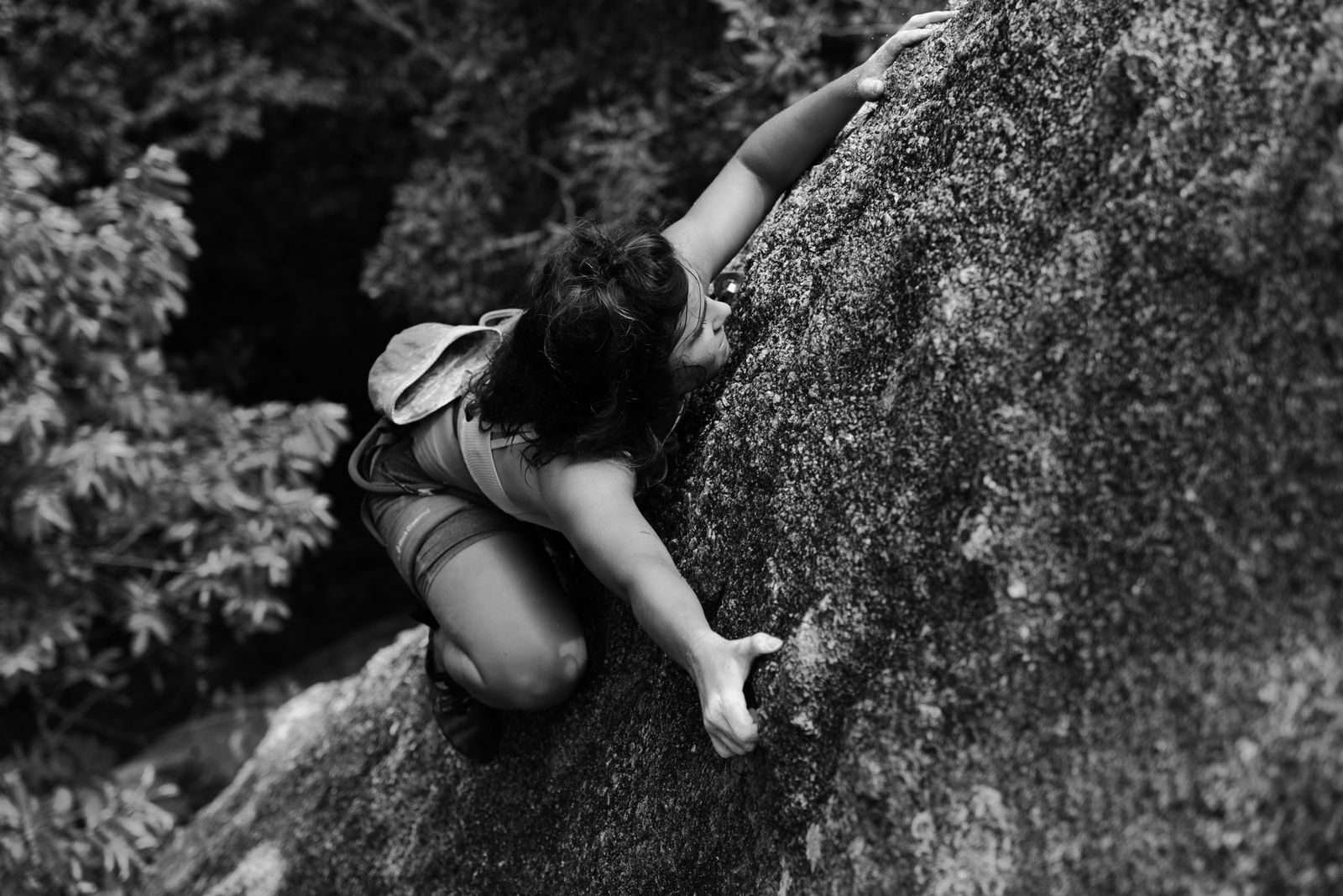 A determined woman climbing a rock face, showcasing strength and adventure in nature.